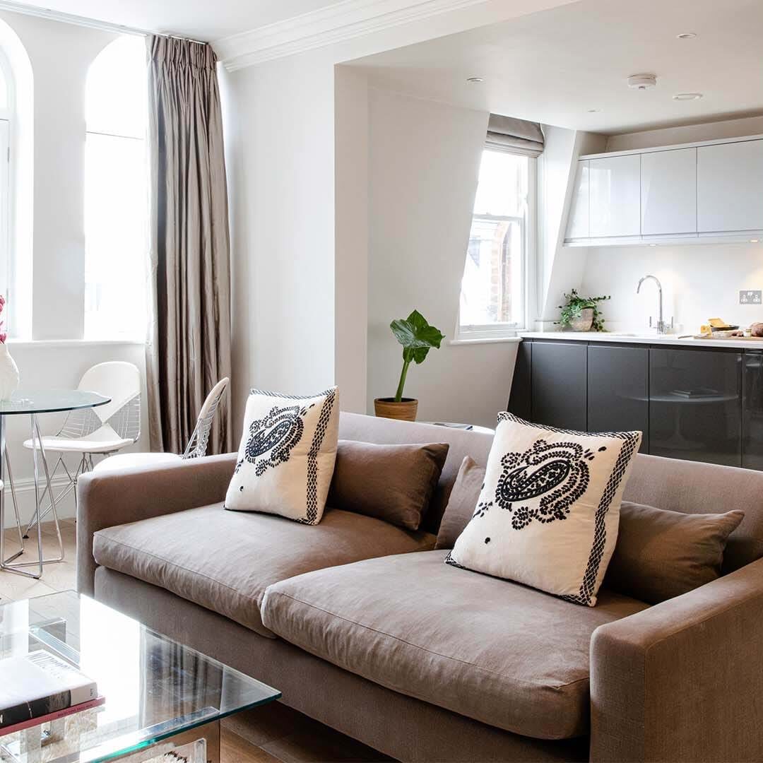 A 56 Welbeck Street apartment, with am open-plan kitchen, soda, coffee table and dining area.